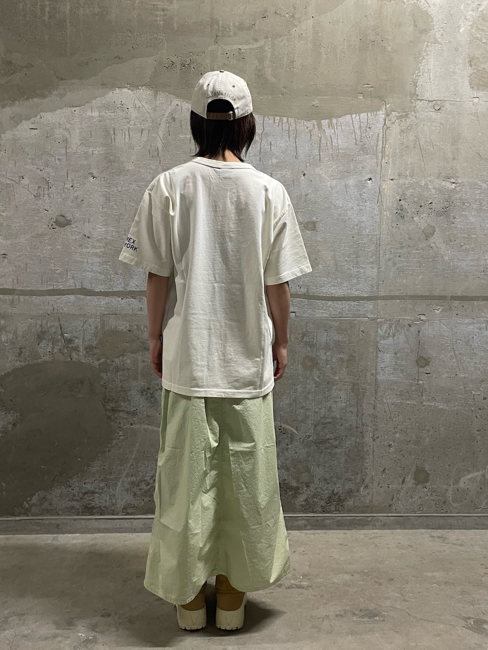 その他のTシャツ/カットソー、グリーン系のスカート、ホワイト系のキャップを着用したレディースの春コーディネートの2枚目の写真