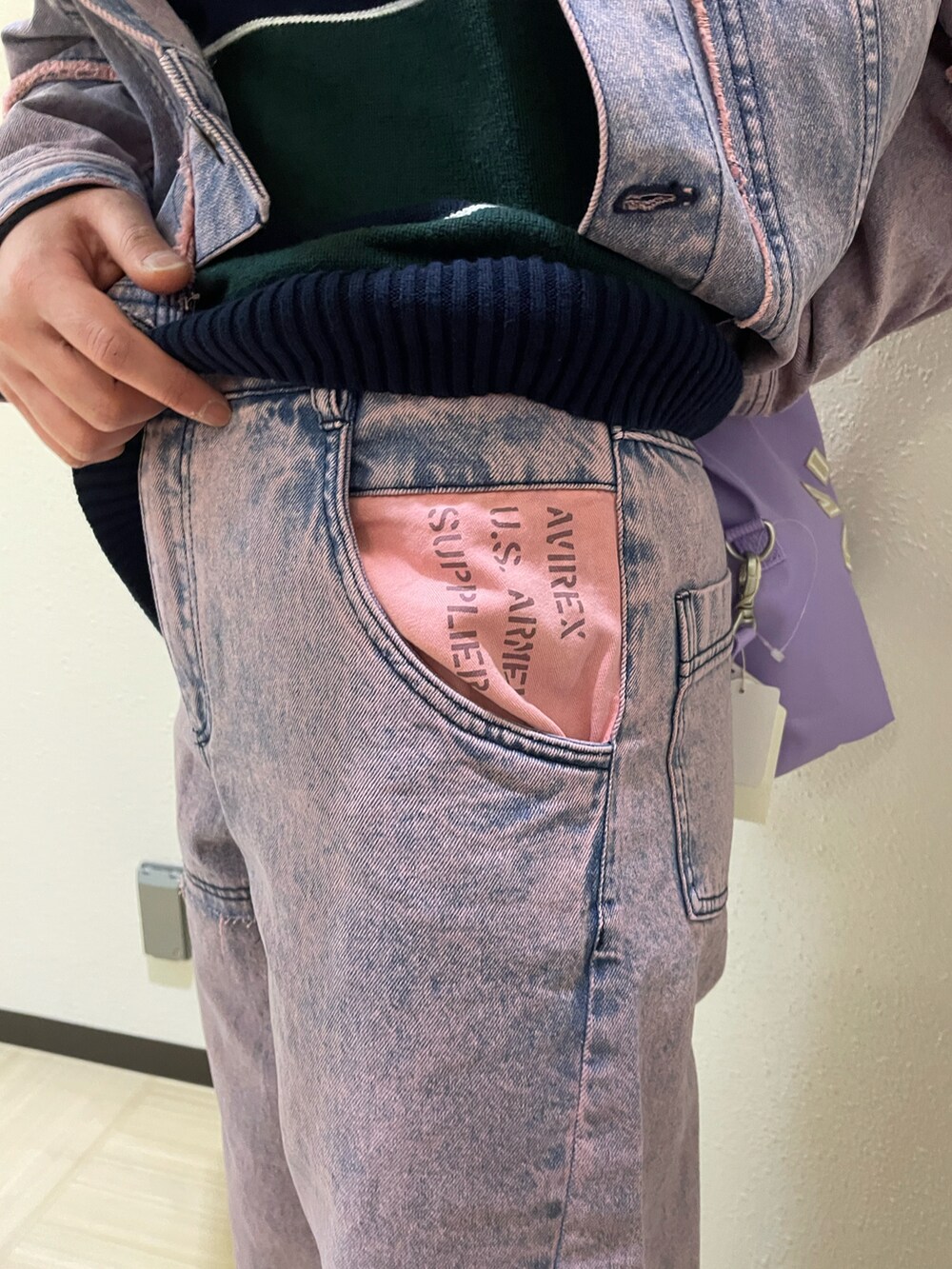 ピンク系のデニムジャケット、ピンク系のデニムパンツ、パープル系のショルダーバッグを着用したレディースの冬コーディネートの5枚目の写真