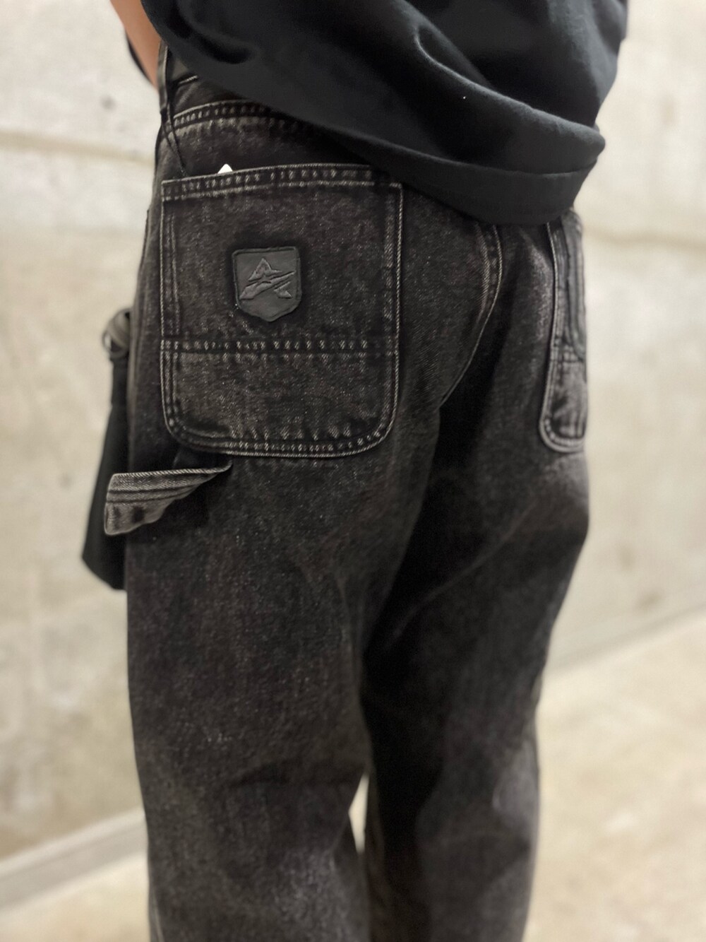 ブラック系のTシャツ/カットソー、ブラック系のショルダーバッグ、ブラック系のデニムパンツを着用したレディースの夏コーディネートの8枚目の写真