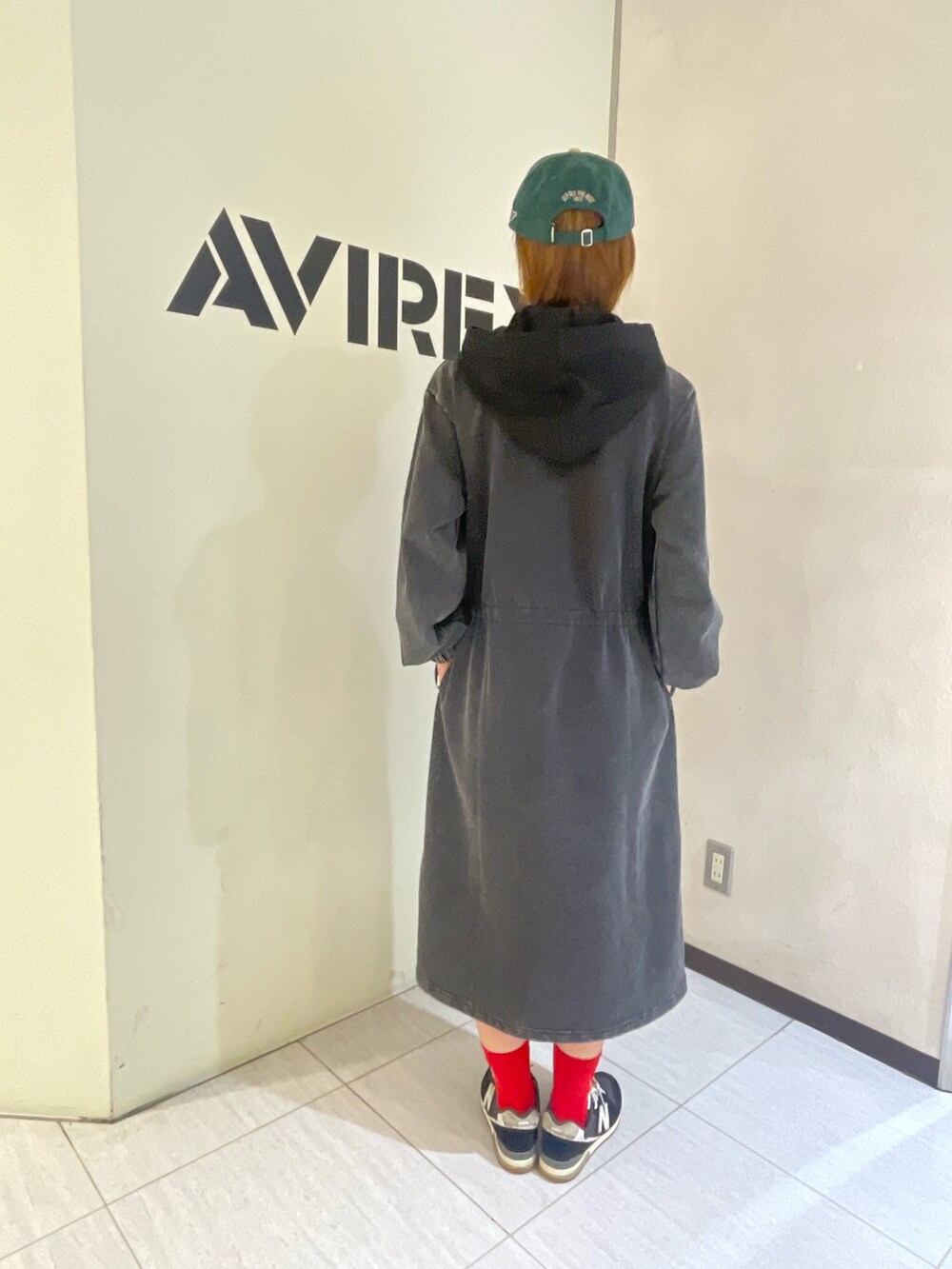 ブラック系のタンクトップ、ブラック系のワンピース、グリーン系のキャップを着用したレディースの秋コーディネートの2枚目の写真