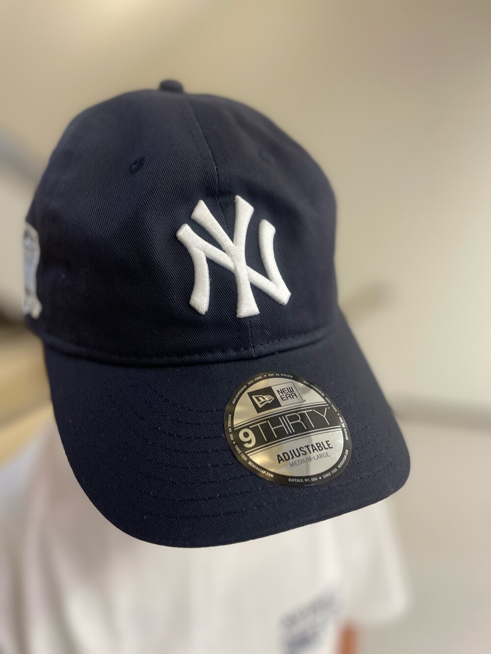 ホワイト系のTシャツ/カットソー、ブラック系のショルダーバッグ、ブルー系のキャップを着用したレディースの夏コーディネートの6枚目の写真