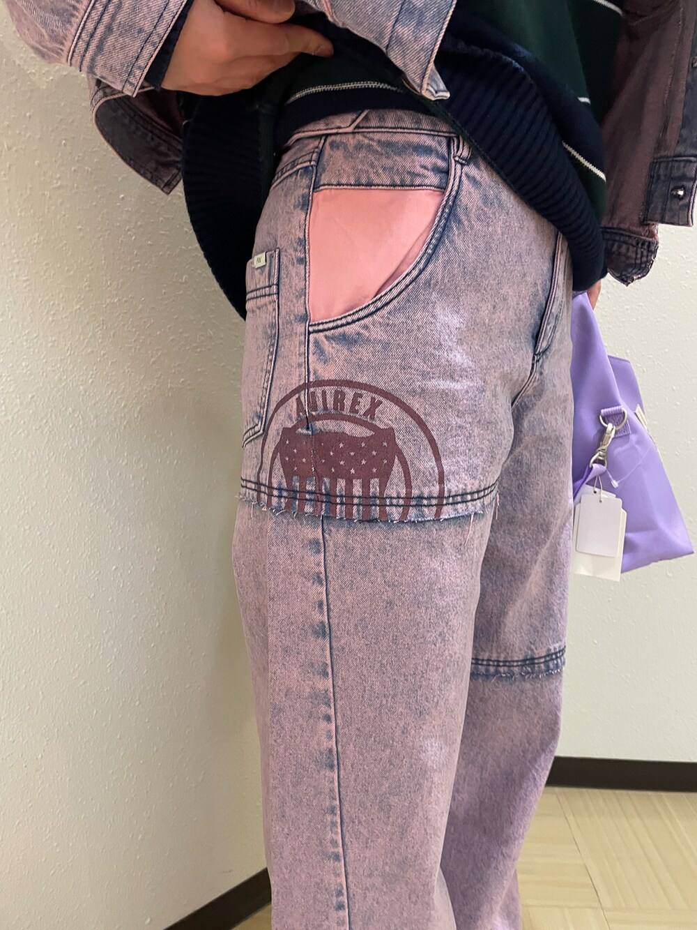 ピンク系のデニムジャケット、ピンク系のデニムパンツ、パープル系のショルダーバッグを着用したレディースの冬コーディネートの4枚目の写真