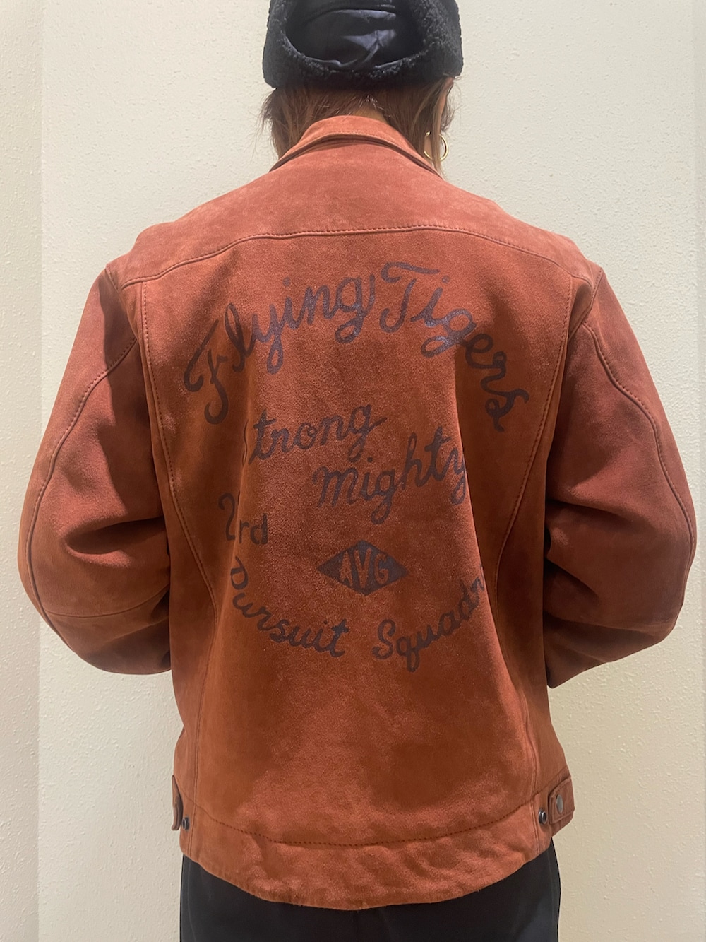 グレー系のスウェット、レッド系のライダースジャケット、ブラック系のキャップを着用したレディースの冬コーディネートの3枚目の写真