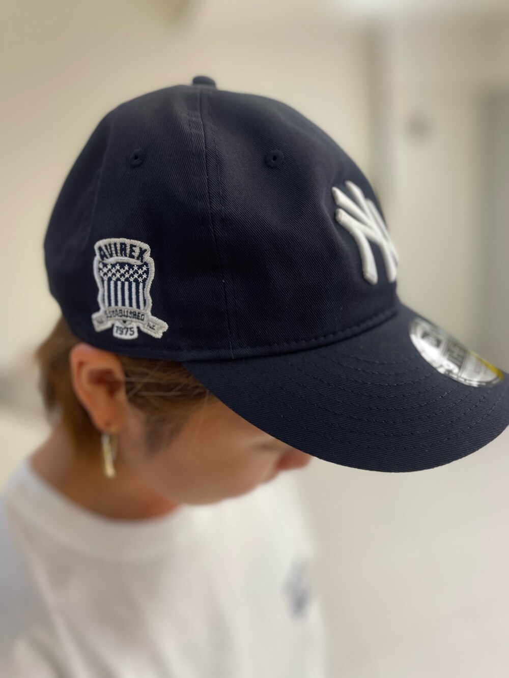 ホワイト系のTシャツ/カットソー、ブラック系のショルダーバッグ、ブルー系のキャップを着用したレディースの夏コーディネートの5枚目の写真