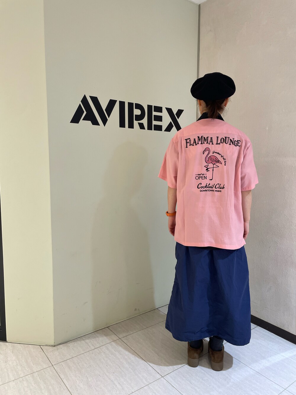 ピンク系のシャツ/ブラウス、ブラック系のTシャツ/カットソー、ブルー系のスカートを着用したレディースの春コーディネートの2枚目の写真