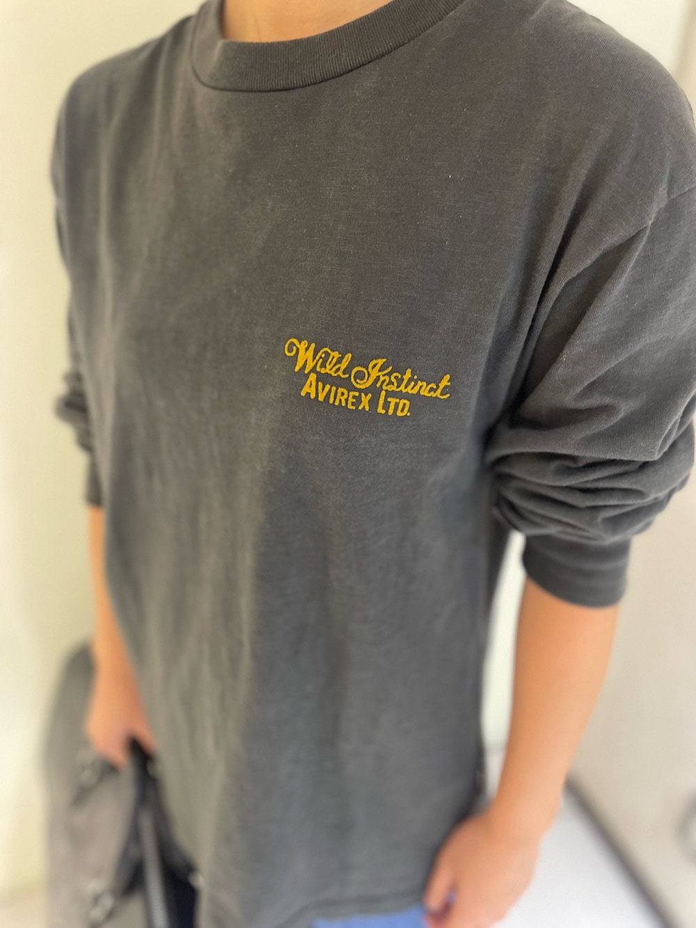 ブラック系のTシャツ/カットソー、ブラック系のボストンバッグ、グリーン系のキャップを着用したレディースの秋コーディネートの3枚目の写真