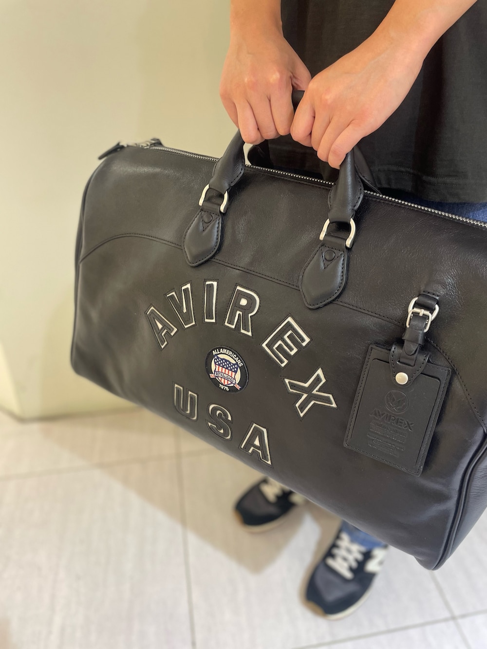 ブラック系のTシャツ/カットソー、ブラック系のボストンバッグ、グリーン系のキャップを着用したレディースの秋コーディネートの5枚目の写真