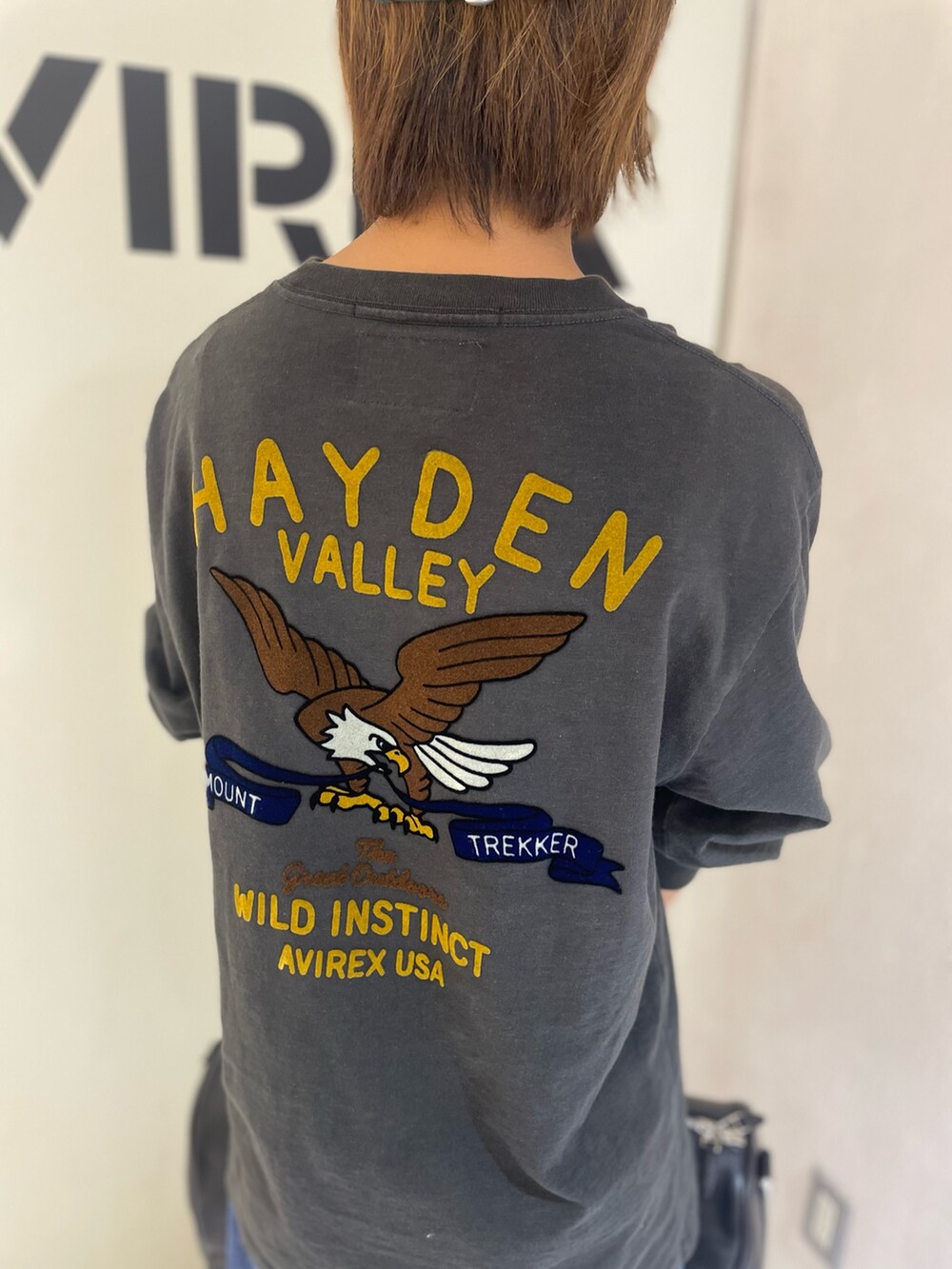 ブラック系のTシャツ/カットソー、ブラック系のボストンバッグ、グリーン系のキャップを着用したレディースの秋コーディネートの4枚目の写真