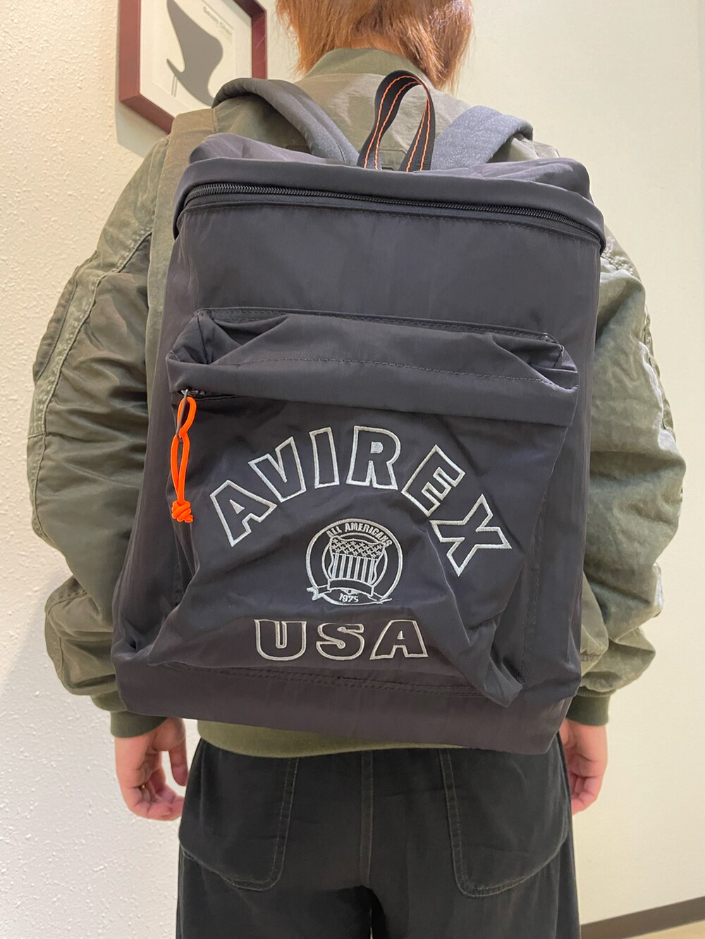 グリーン系のMA-1、ブラック系のバックパック/リュック、その他のキャップを着用したレディースの夏コーディネートの3枚目の写真