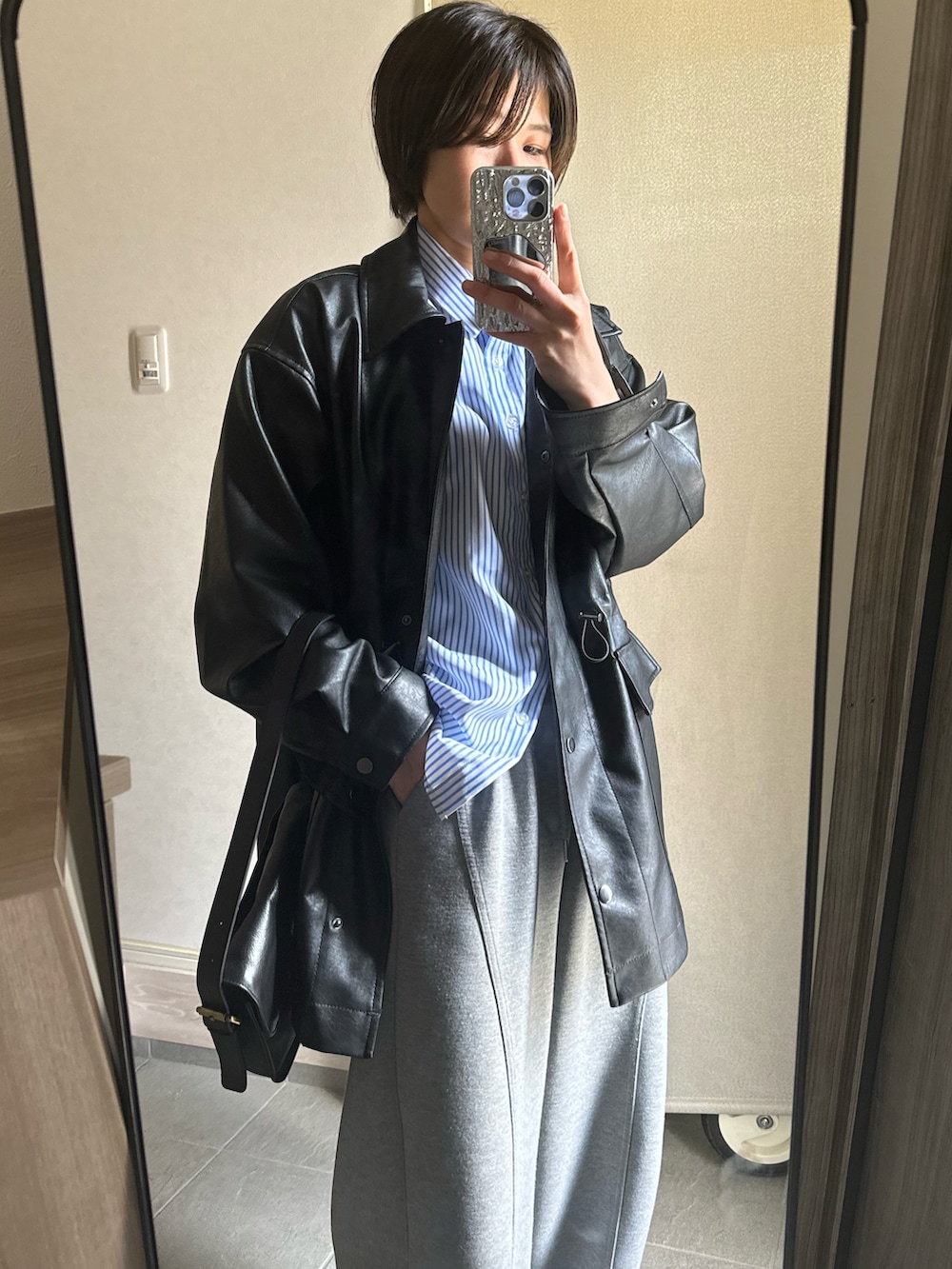 ブルー系のシャツ/ブラウス、ブラック系のブルゾン、グレー系のスウェットパンツを着用したレディースの春コーディネートの2枚目の写真