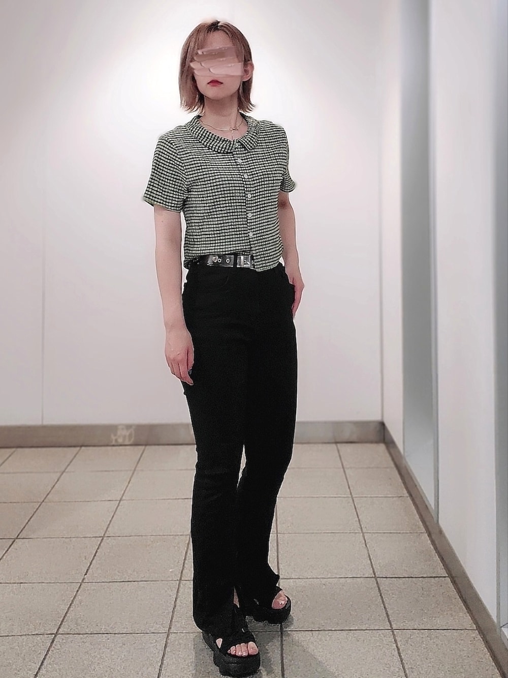 グリーン系のトップス、ブラック系のパンツ、ブラック系のサンダルを着用したレディースの夏コーディネートの2枚目の写真