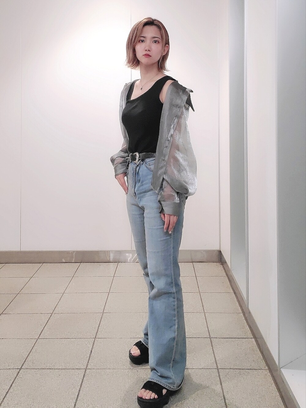 ブルー系のデニムパンツ、ブラック系のサンダル、ブラック系のタンクトップを着用したレディースの夏コーディネートの2枚目の写真