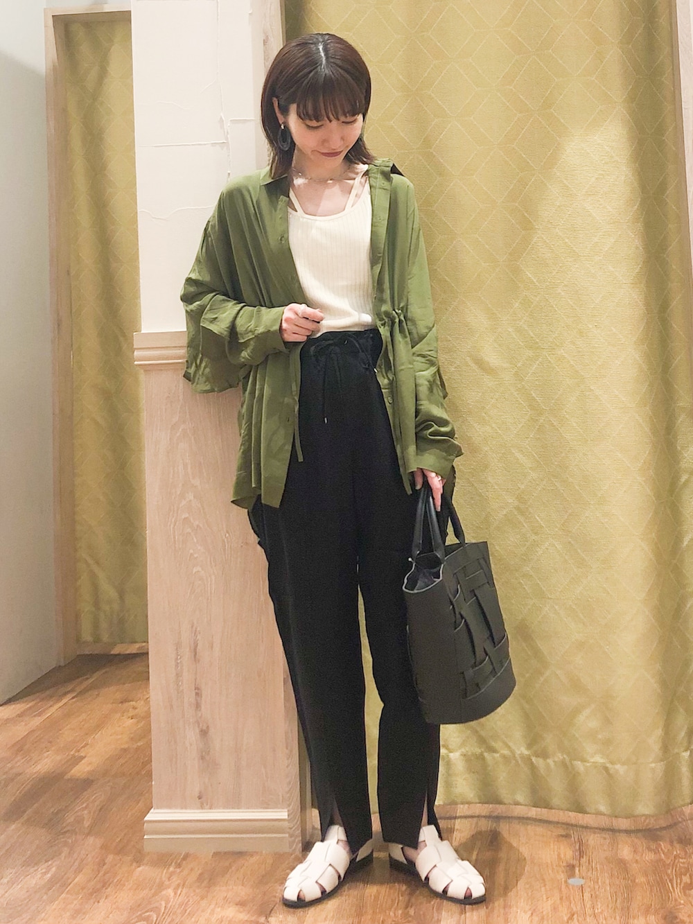 ブラック系のその他パンツ、グリーン系のシャツ/ブラウス、ホワイト系のタンクトップを着用したレディースの春コーディネートの2枚目の写真