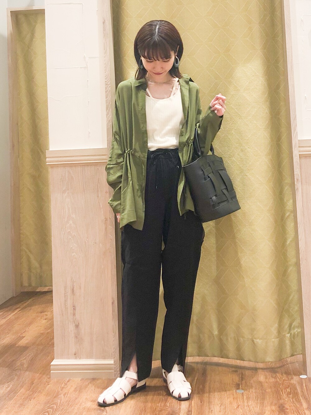 ブラック系のその他パンツ、グリーン系のシャツ/ブラウス、ホワイト系のタンクトップを着用したレディースの春コーディネートの3枚目の写真