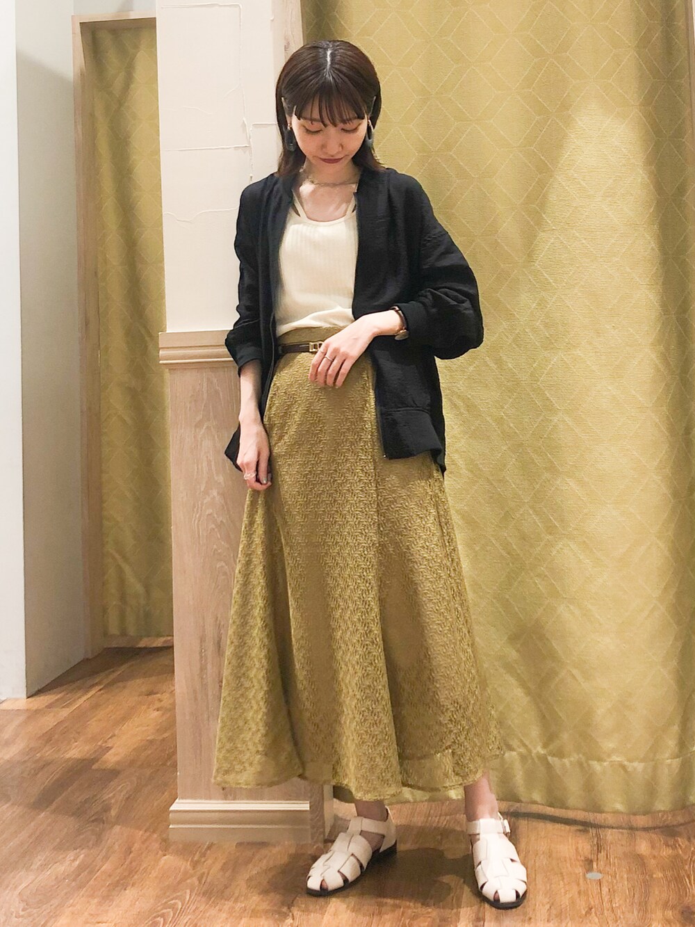 ホワイト系のタンクトップ、ブラック系のMA-1、グリーン系のスカートを着用したレディースの春コーディネートの3枚目の写真