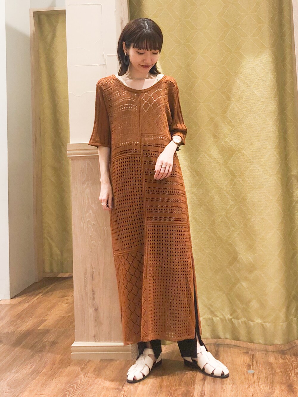 オレンジ系のワンピース、ホワイト系のタンクトップ、ブラック系のその他パンツを着用したレディースの春コーディネートの2枚目の写真