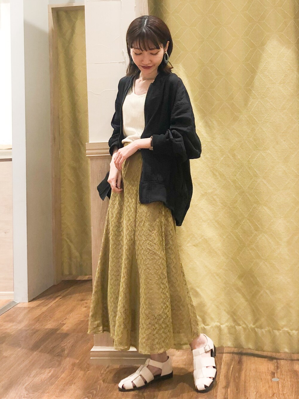 ホワイト系のタンクトップ、ブラック系のMA-1、グリーン系のスカートを着用したレディースの春コーディネートの2枚目の写真