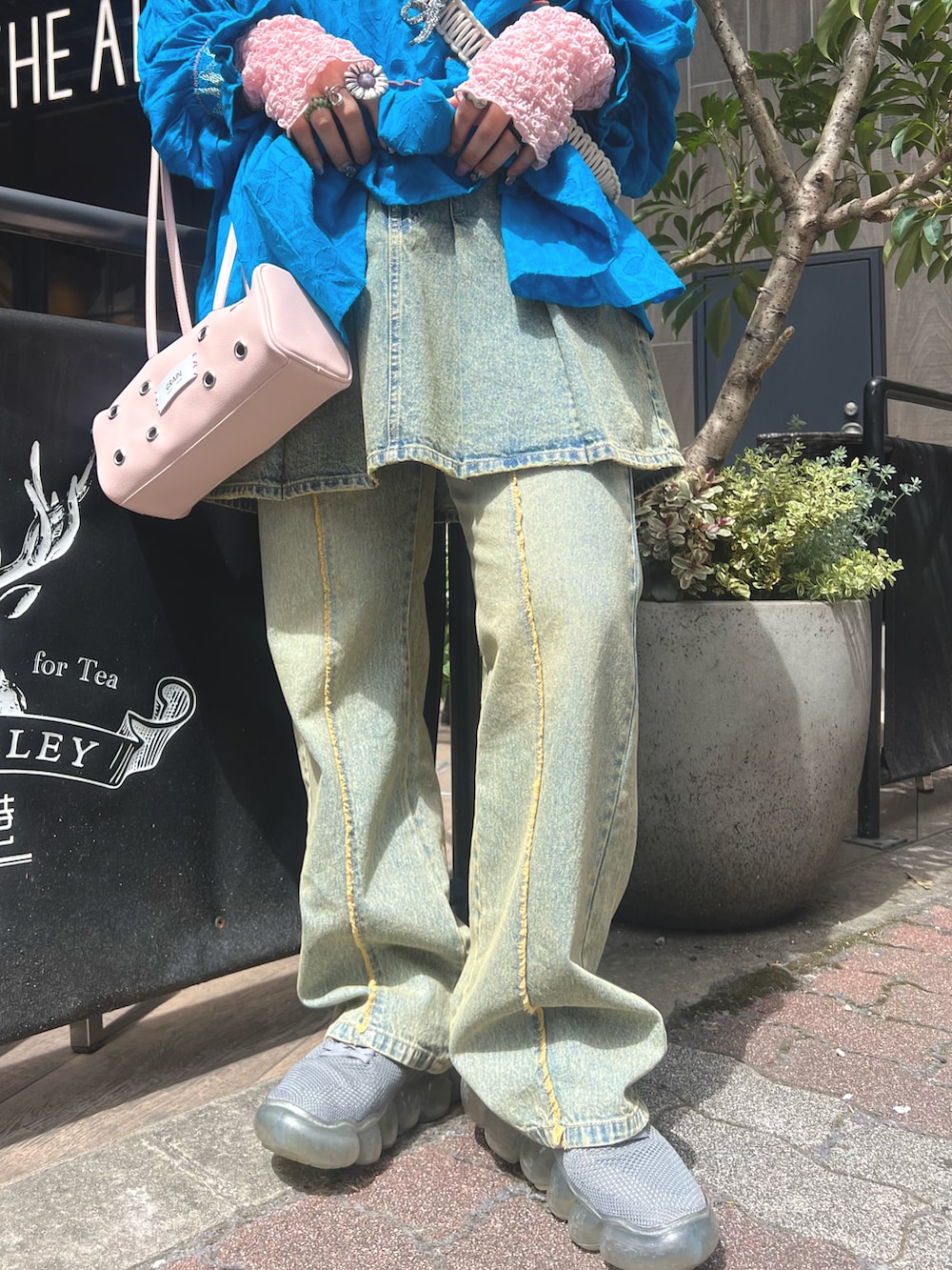 ブルー系のトップス、ブルー系のデニムパンツ、ピンク系のバッグを着用したレディースの春コーディネートの4枚目の写真