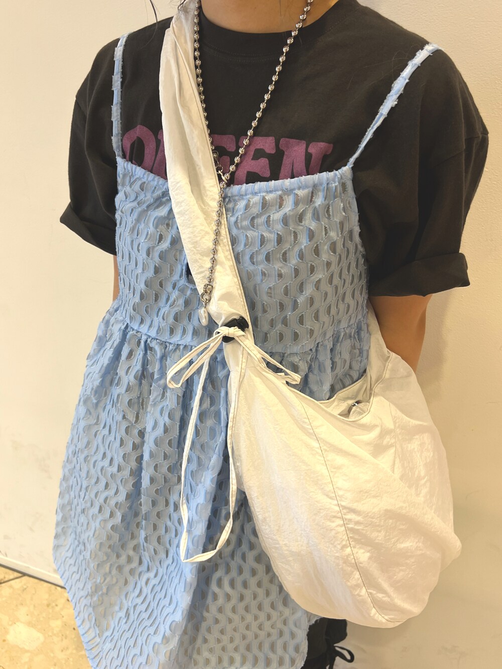 ホワイト系のショルダーバッグ、ブルー系のキャミソール、グレー系のTシャツ/カットソーを着用したレディースの夏コーディネートの4枚目の写真