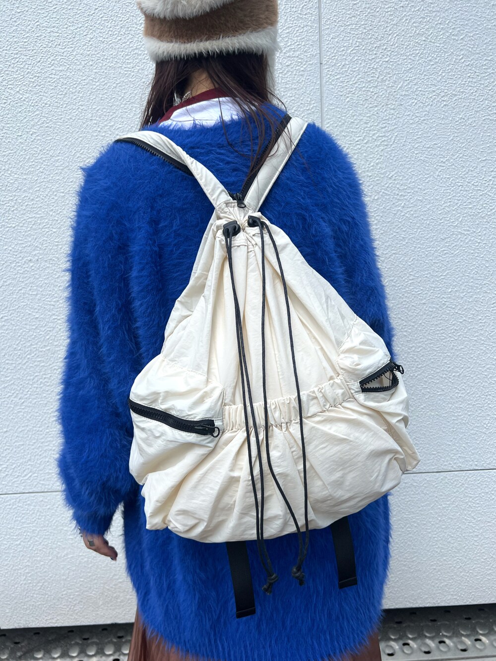 ブルー系のカーディガン/ボレロ、ブラウン系のワンピース、ホワイト系のバックパック/リュックを着用したレディースの秋コーディネートの5枚目の写真