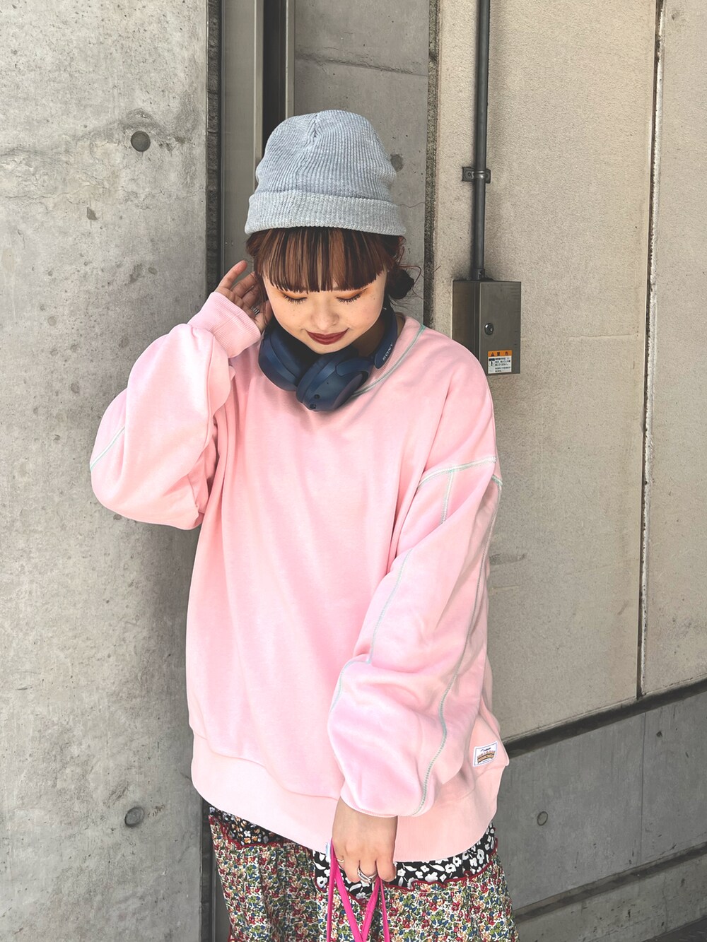 ピンク系のスウェット、ピンク系のワンピース、グレー系のニットキャップ/ビーニーを着用したレディースの春コーディネートの3枚目の写真