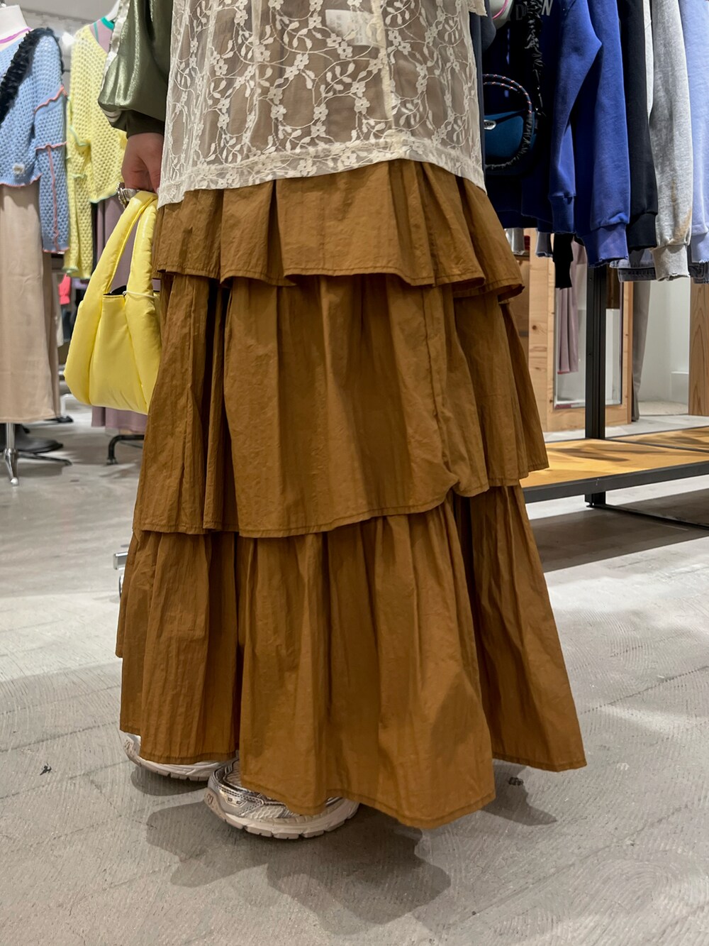 グリーン系のTシャツ/カットソー、イエロー系のスカート、イエロー系のハンドバッグを着用したレディースの春コーディネートの5枚目の写真