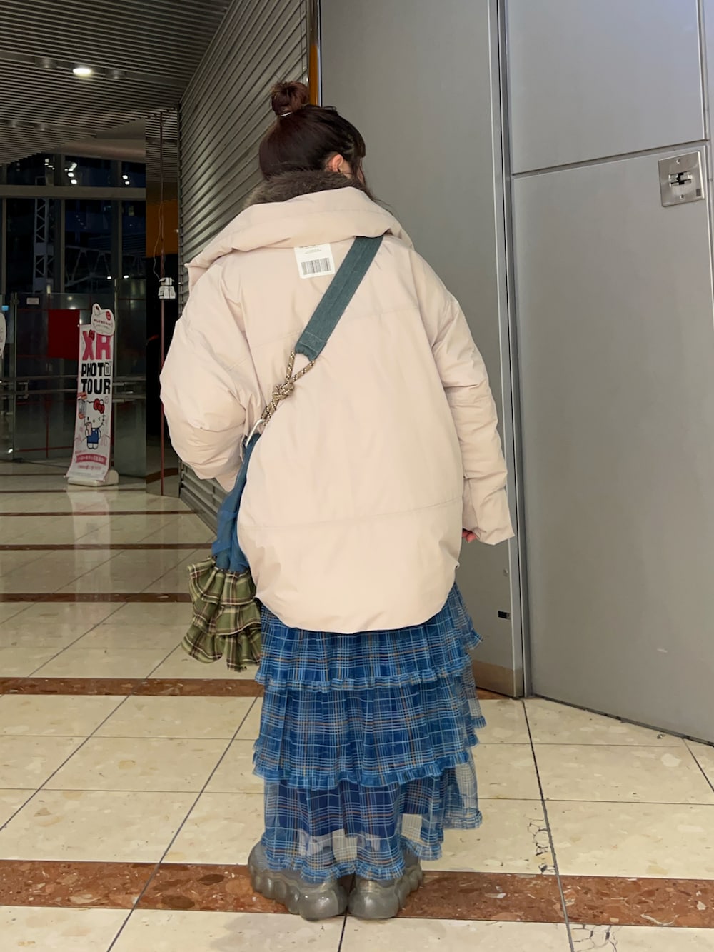 ブラック系のバッグ、グレー系のダウンジャケット/コート、ブルー系のスカートを着用したレディースの冬コーディネートの2枚目の写真