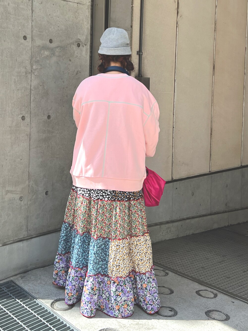 ピンク系のスウェット、ピンク系のワンピース、グレー系のニットキャップ/ビーニーを着用したレディースの春コーディネートの2枚目の写真