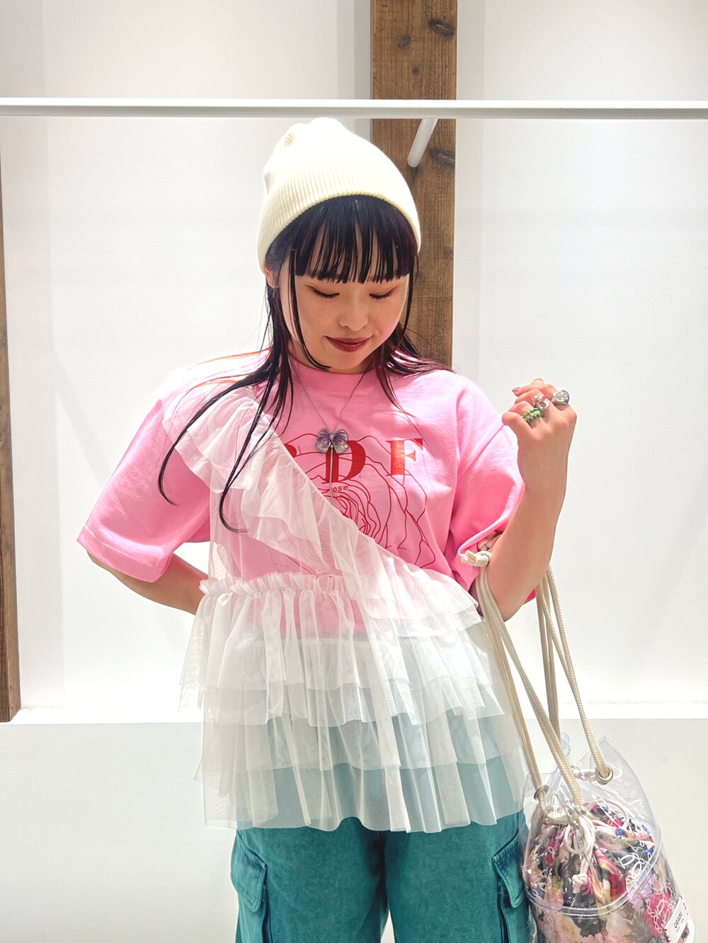 ホワイト系のベスト、ピンク系のTシャツ/カットソー、グリーン系のデニムパンツを着用したレディースの春コーディネートの4枚目の写真