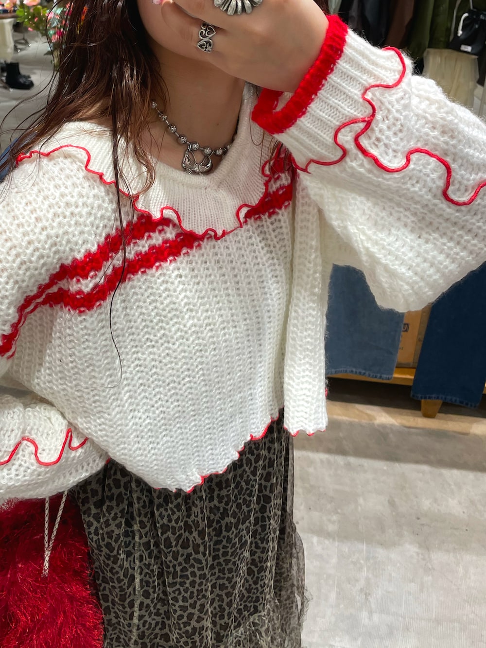 ホワイト系のニット/セーター、ベージュ系のスカート、レッド系のショルダーバッグを着用したレディースの秋コーディネートの4枚目の写真