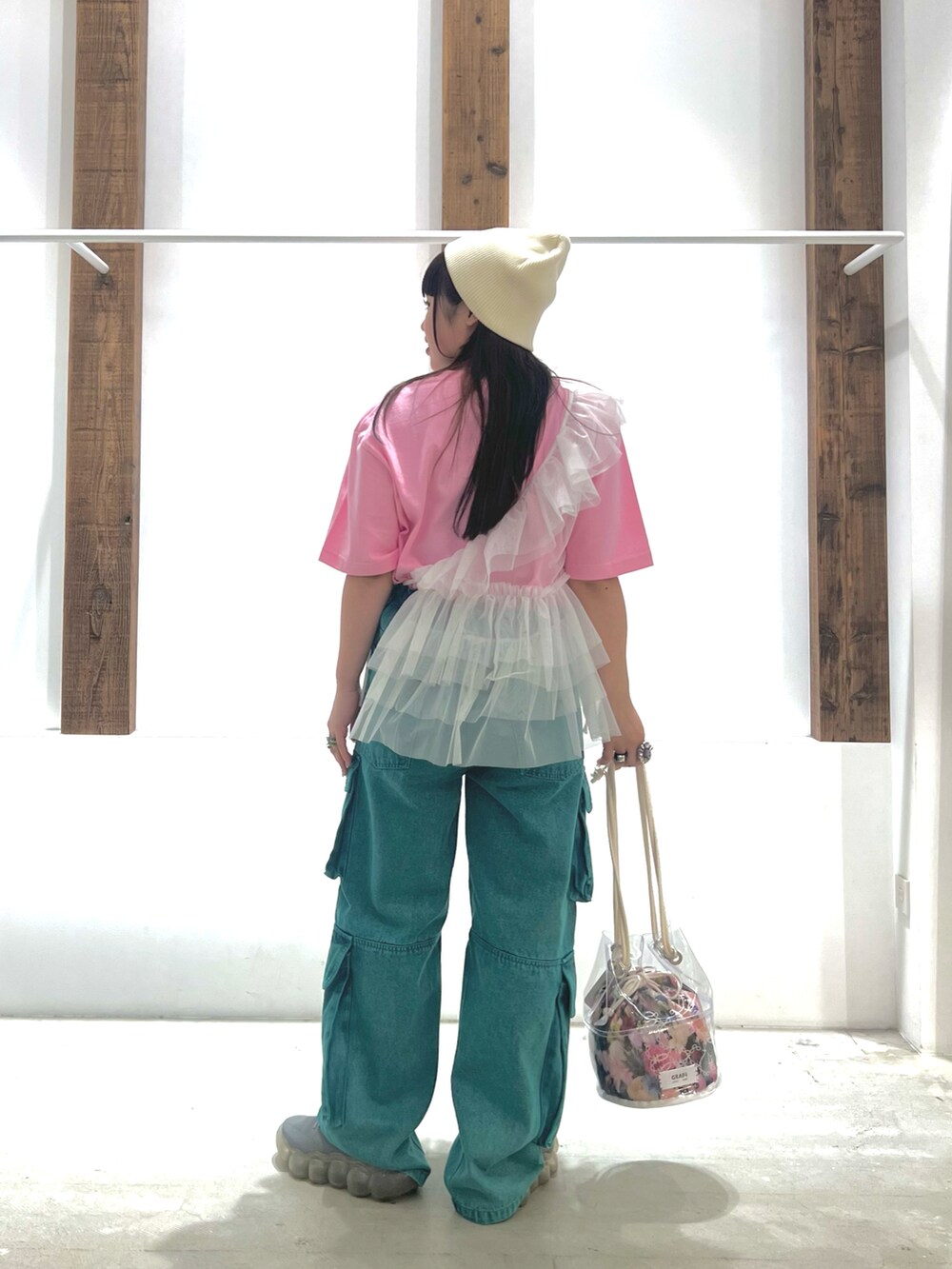 ホワイト系のベスト、ピンク系のTシャツ/カットソー、グリーン系のデニムパンツを着用したレディースの春コーディネートの3枚目の写真