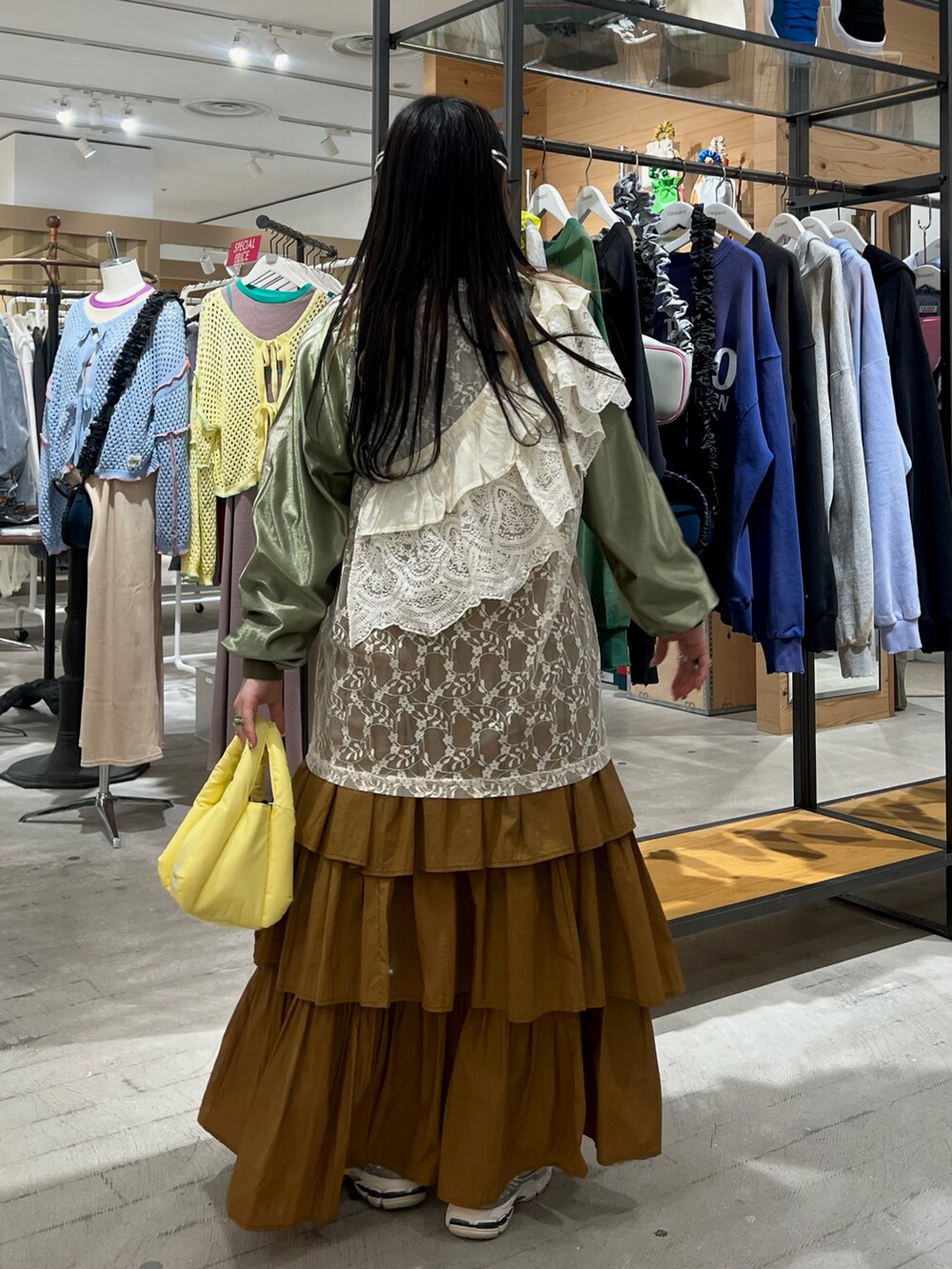 グリーン系のTシャツ/カットソー、イエロー系のスカート、イエロー系のハンドバッグを着用したレディースの春コーディネートの2枚目の写真