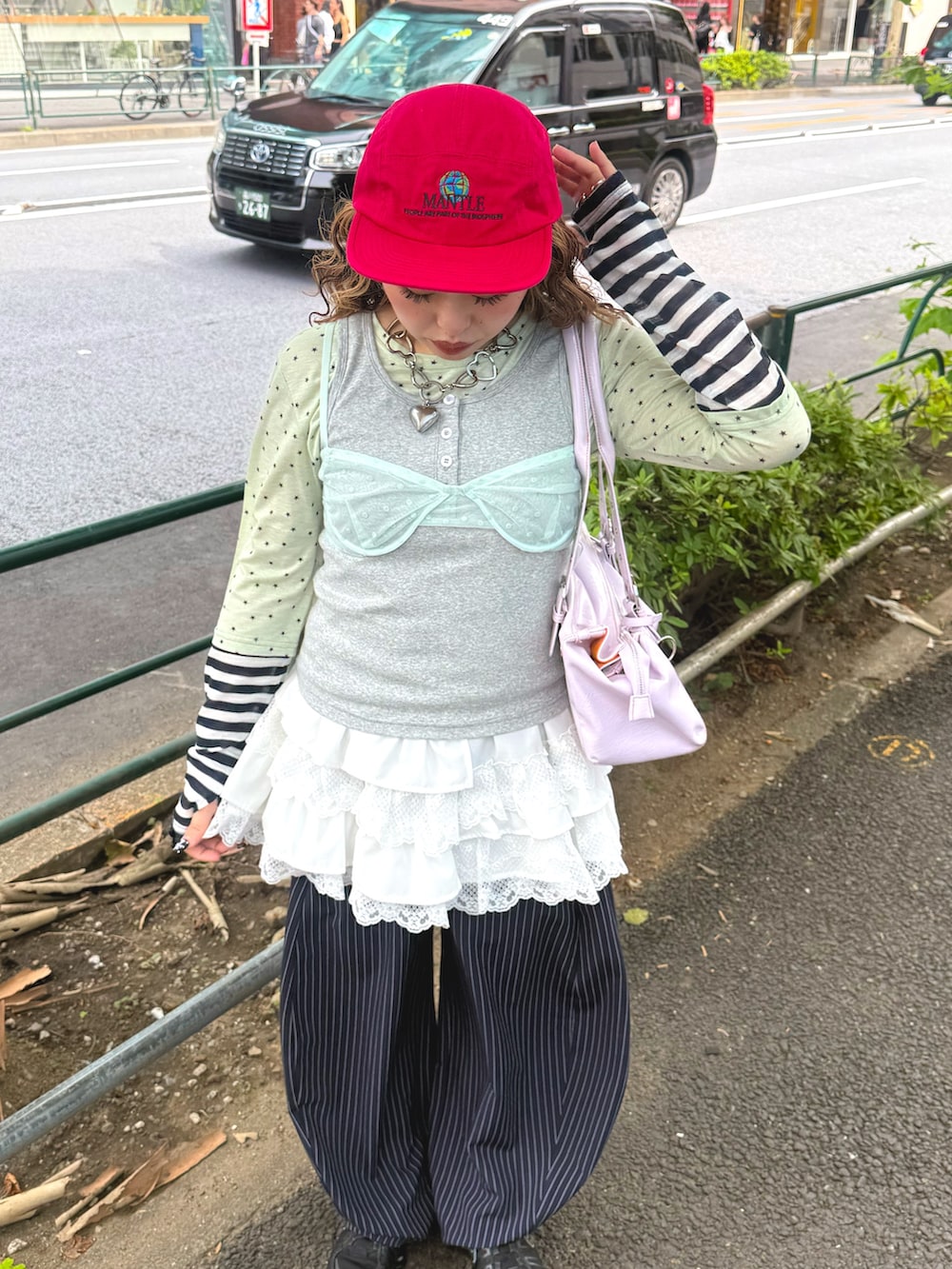 グリーン系のキャミソール、グレー系のTシャツ/カットソー、ブルー系のスラックスを着用したレディースの夏コーディネートの2枚目の写真