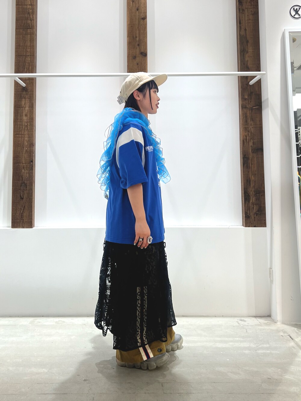 ブルー系のTシャツ/カットソー、ブラック系のワンピース、グリーン系のカーゴパンツを着用したレディースの春コーディネートの2枚目の写真