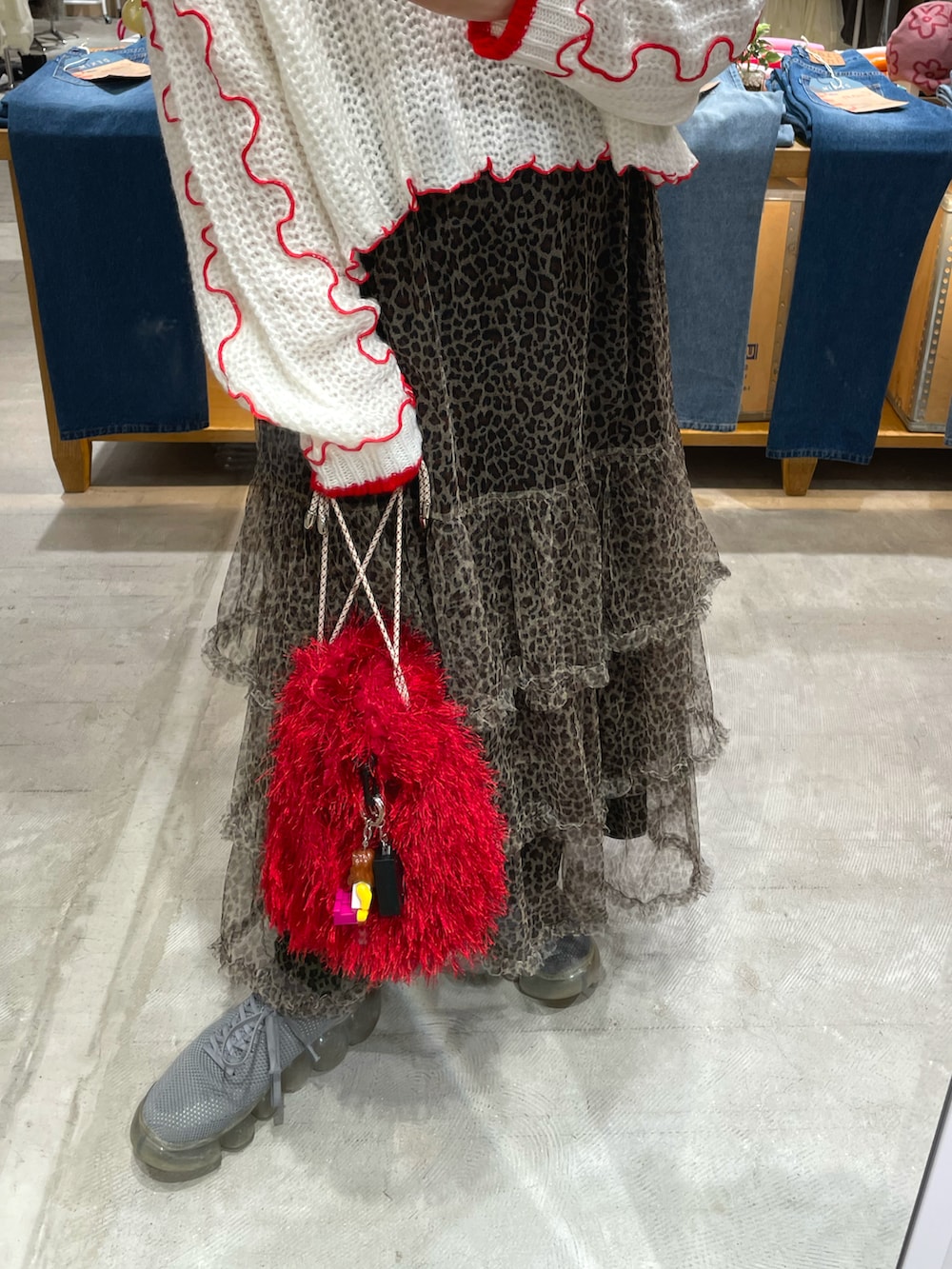 ホワイト系のニット/セーター、ベージュ系のスカート、レッド系のショルダーバッグを着用したレディースの秋コーディネートの3枚目の写真