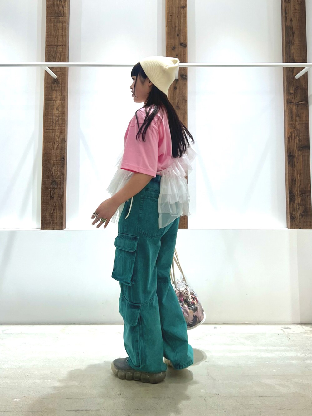 ホワイト系のベスト、ピンク系のTシャツ/カットソー、グリーン系のデニムパンツを着用したレディースの春コーディネートの2枚目の写真