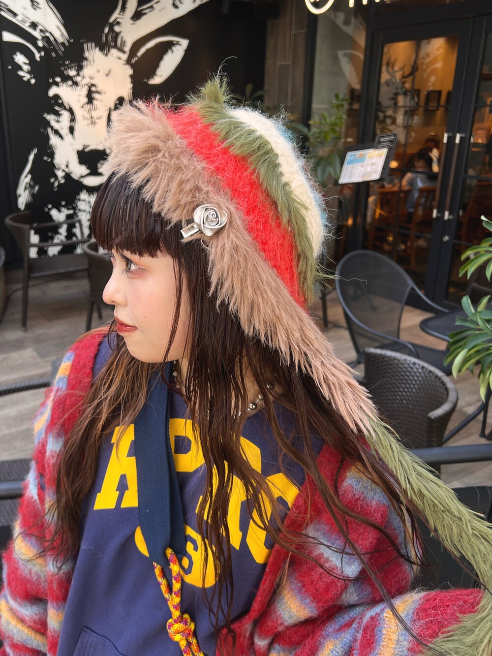 ブラック系のパーカー、レッド系のカーディガン/ボレロ、ブラウン系のスカートを着用したレディースの秋コーディネートの5枚目の写真