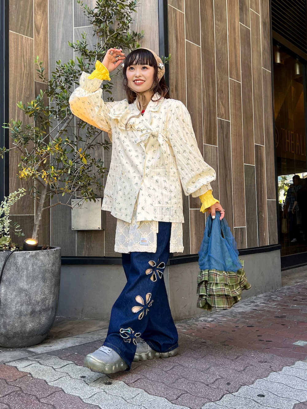 ホワイト系のテーラードジャケット、ブルー系のバッグ、ホワイト系のスカートを着用したレディースの秋コーディネートの2枚目の写真