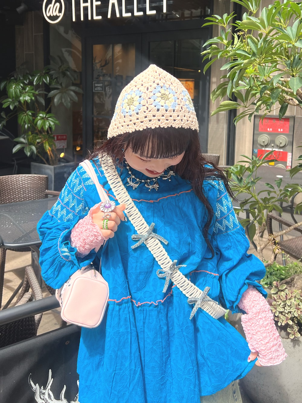 ブルー系のトップス、ブルー系のデニムパンツ、ピンク系のバッグを着用したレディースの春コーディネートの3枚目の写真