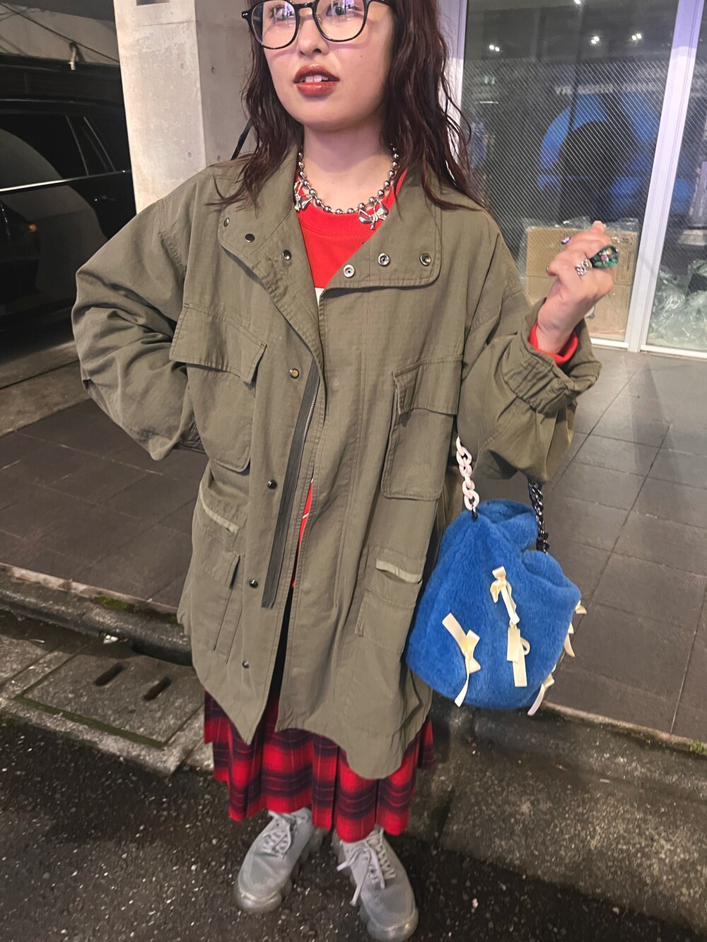 レッド系のスウェット、グリーン系のモッズコート、レッド系のスカートを着用したレディースの秋コーディネートの3枚目の写真