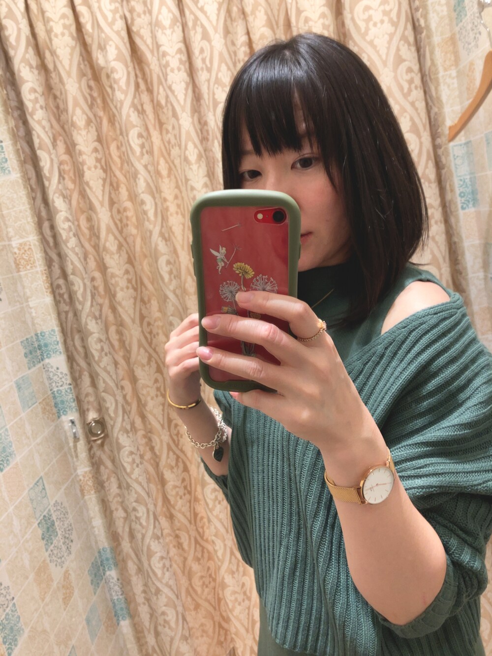 ブラウン系のパンプス、グリーン系のワンピース、ホワイト系のマウンテンパーカーを着用したレディースの秋コーディネートの2枚目の写真