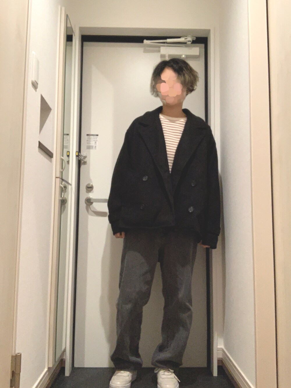 ブラック系のデニムパンツ、ブラック系のトレンチコート、ベージュ系のその他トップスを着用したレディースの冬コーディネートの2枚目の写真