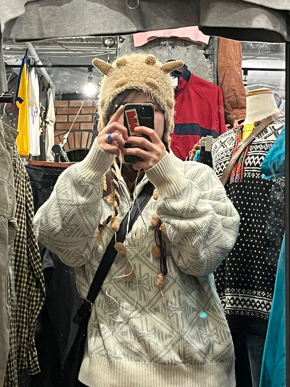 ホワイト系のニット/セーター、ブラック系のスウェットパンツ、ブルー系のスニーカーを着用したレディースの冬コーディネートの2枚目の写真