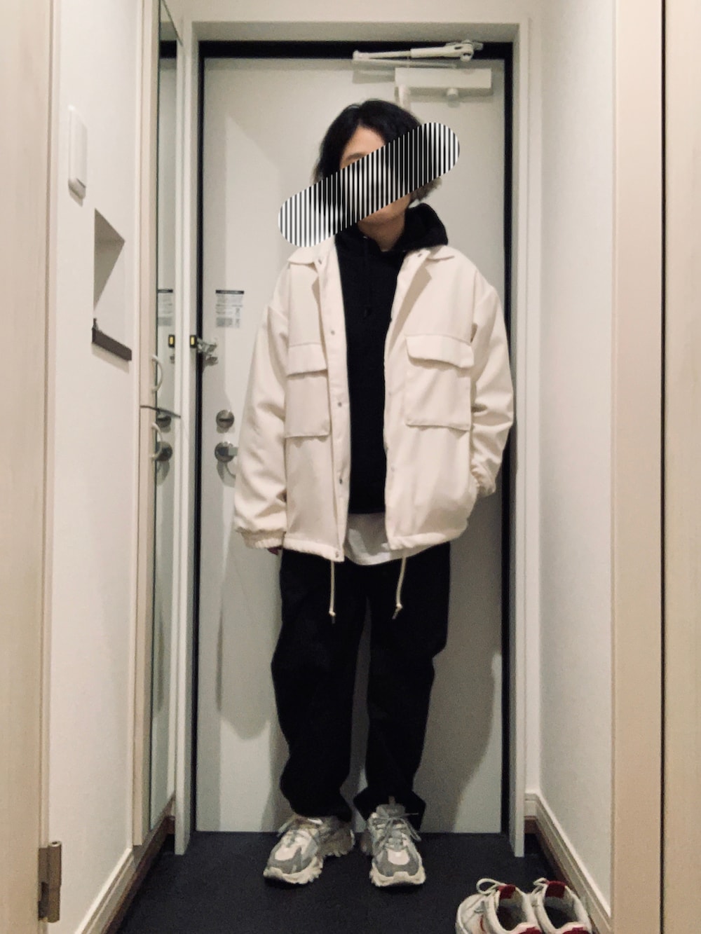 ブラック系のパーカー、ブラック系のパンツ、グレー系のスニーカーを着用したレディースの冬コーディネートの2枚目の写真