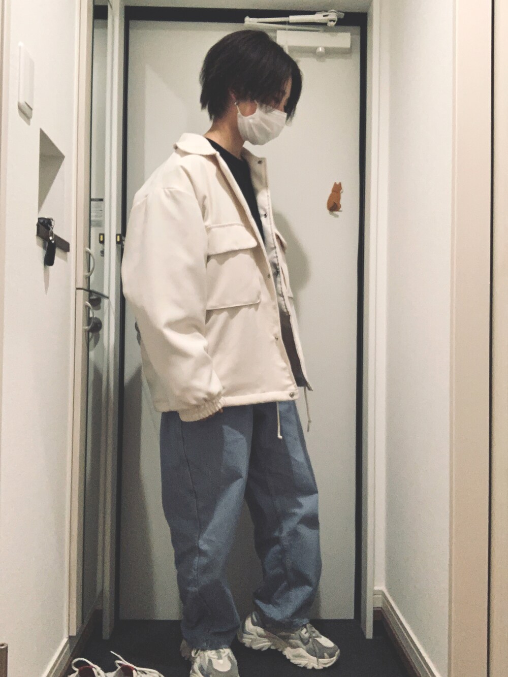 ブルー系のデニムパンツ、ホワイト系のその他アウター、ブラック系のTシャツ/カットソーを着用したレディースの春コーディネートの2枚目の写真