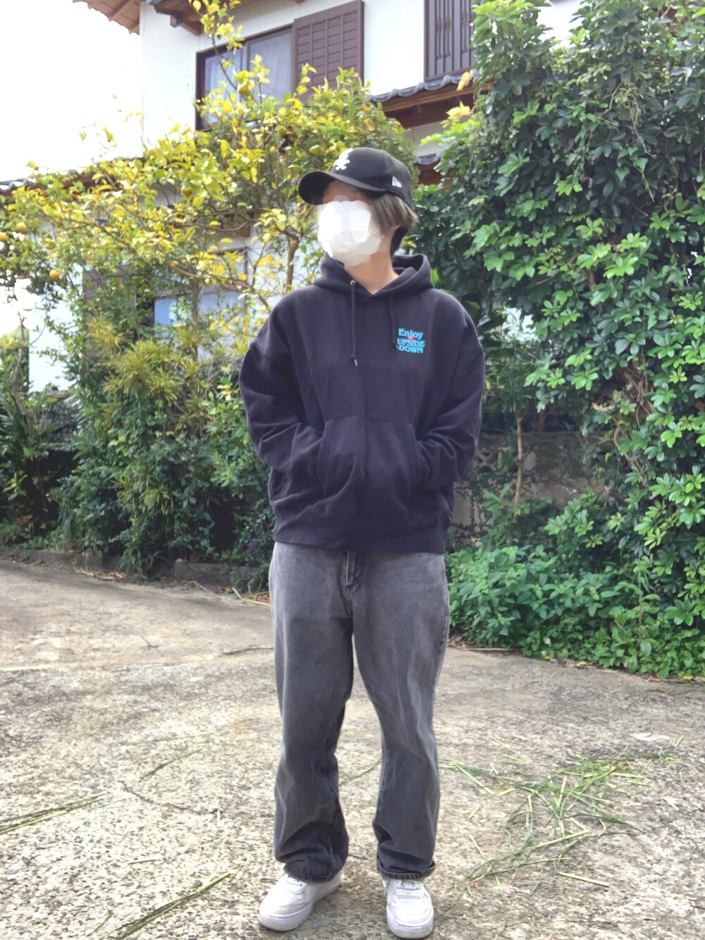 ブラック系のパーカー、ブラック系のデニムパンツ、ホワイト系のスニーカーを着用したレディースの冬コーディネートの3枚目の写真