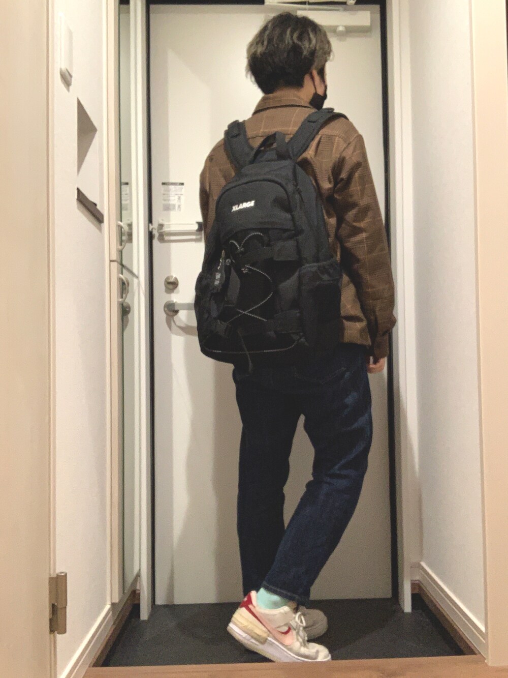 ブルー系のデニムパンツ、ホワイト系のスニーカー、ブラウン系のシャツ/ブラウスを着用したレディースの冬コーディネートの2枚目の写真