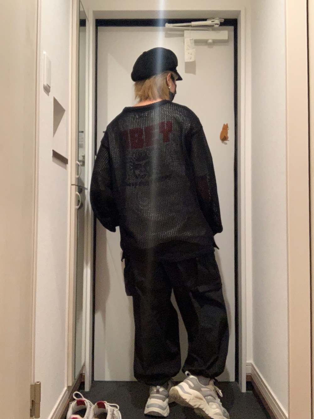 ブラック系のカーゴパンツ、グレー系のスニーカー、ブラック系のニット/セーターを着用したレディースの秋コーディネートの4枚目の写真