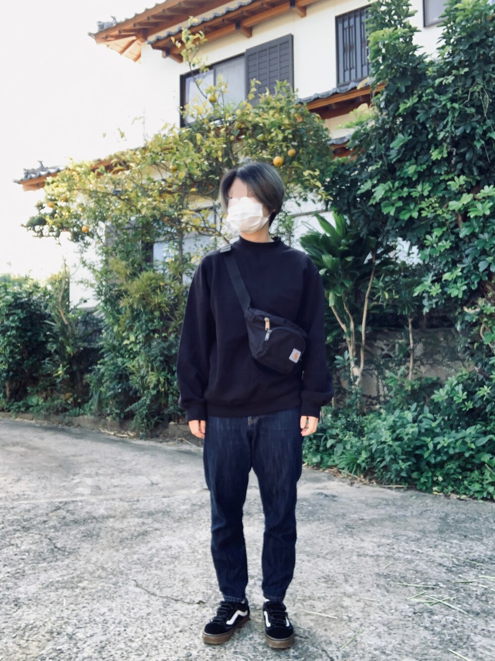 ブルー系のデニムパンツ、ブラック系のスニーカー、ブラック系のスウェットを着用したレディースの冬コーディネートの2枚目の写真