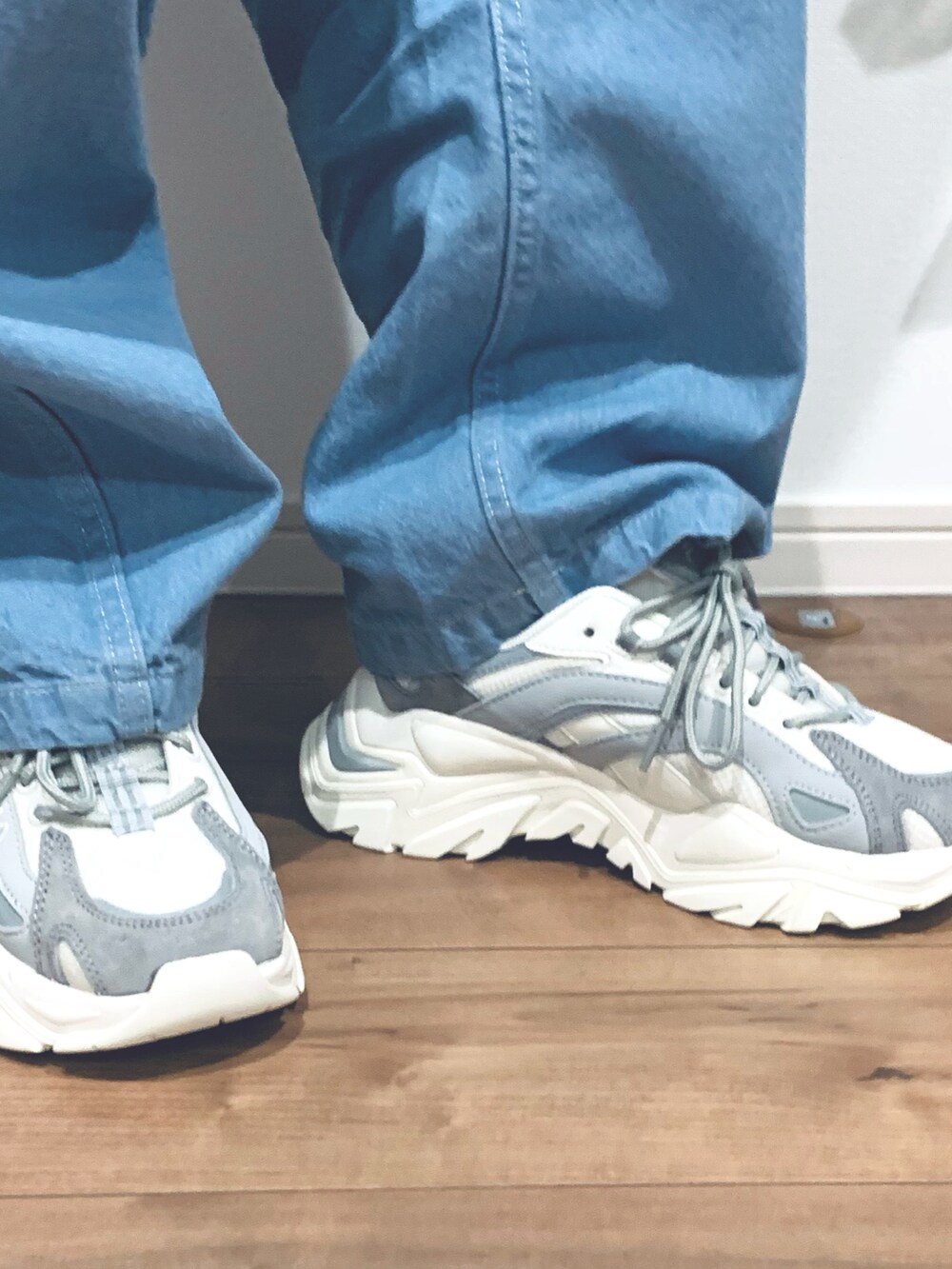 ブルー系のパンツ、グレー系のスニーカー、ブラック系のパーカーを着用したレディースの冬コーディネートの2枚目の写真